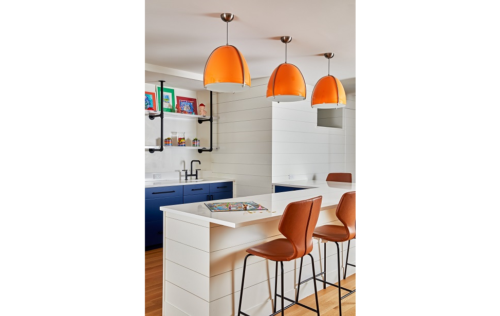 Bright orange lamp shades add accents to this kitchen basement